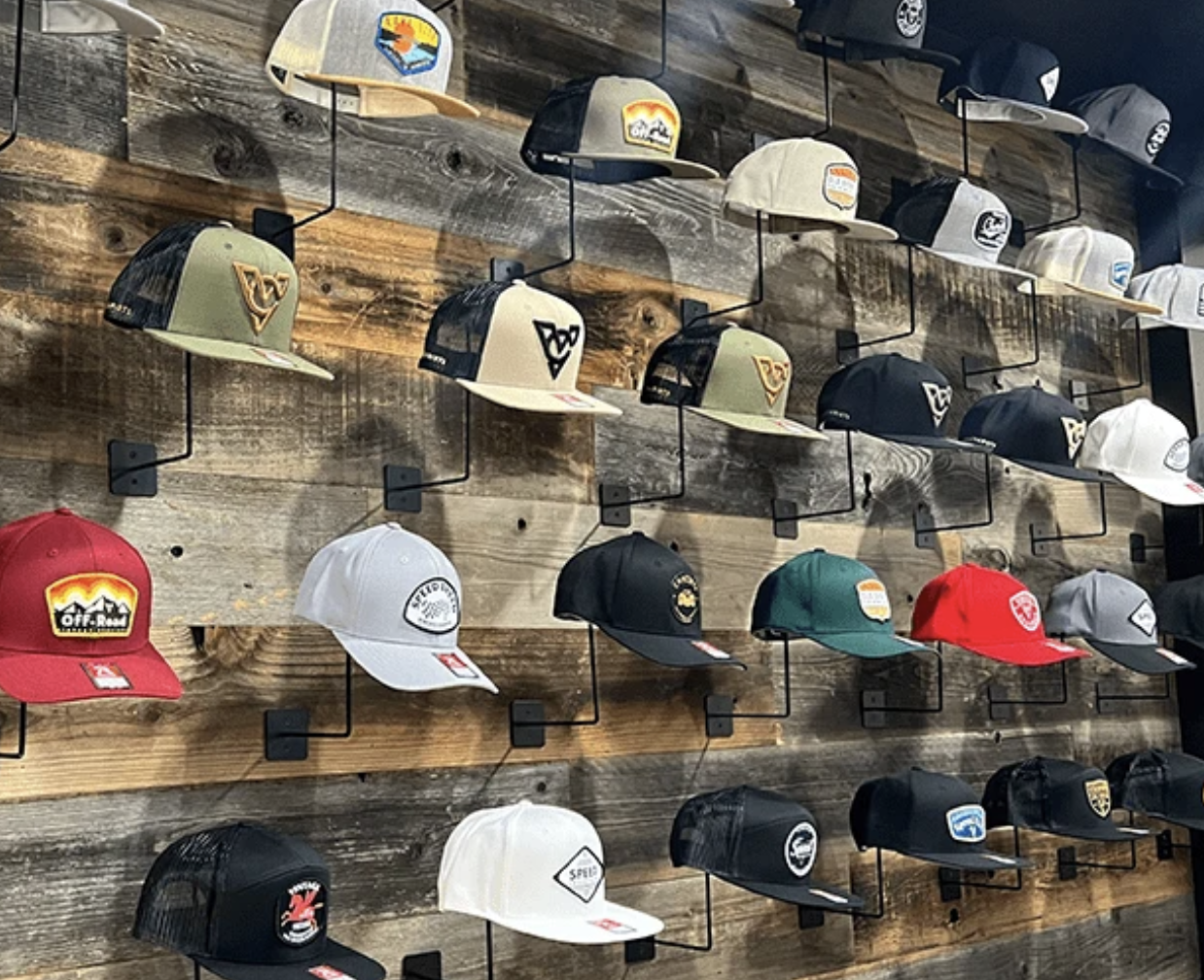 Wall of custom embroidered hats in varied colors and styles
